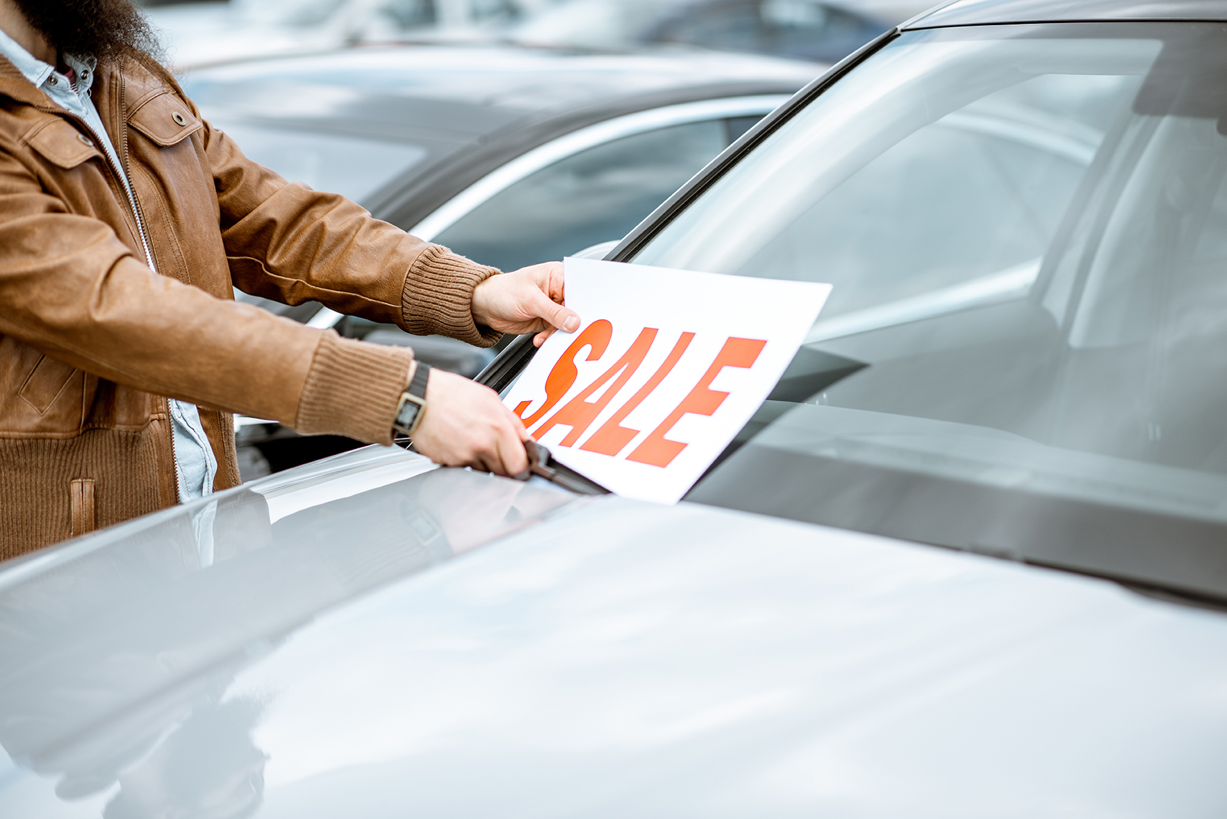 Sale sign placed on a new car in a dealership lot